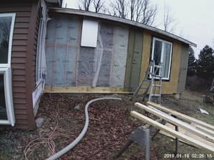 photo of outside of house being insulated with blown in insulation