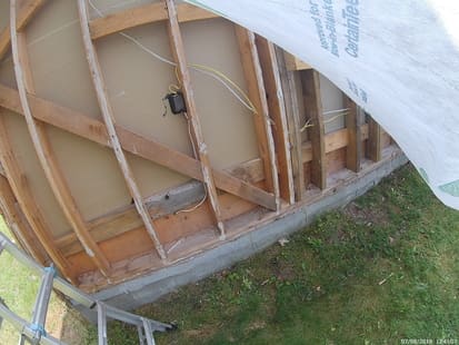 photo of a wall with the sheeting and insulation removed showing the studs and back side of the drywall