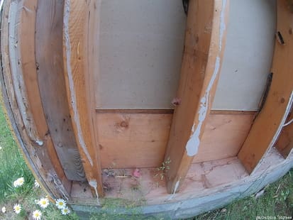 photo of wall from outside with no insulation and the  backside of drywall where it meets the floor