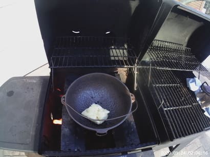 photo of cast iron pot on bbq grill with fat in it